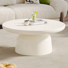 a white coffee table sitting on top of a carpeted floor next to a couch