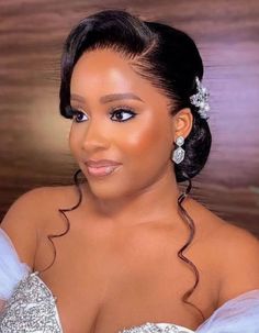 a woman in a wedding dress posing for the camera with her hair pulled back and wearing a tiara