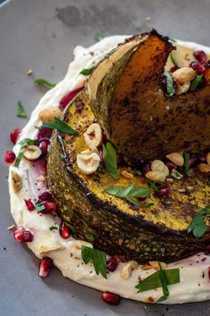 a plate with some food on it and garnished with nuts, leaves and other things