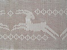 a white crocheted tablecloth with brown dots and a bird on it's back