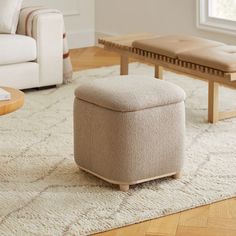 a living room scene with focus on the footstool and coffee table in the background