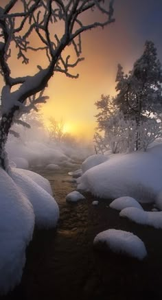 the sun is setting over a snowy river