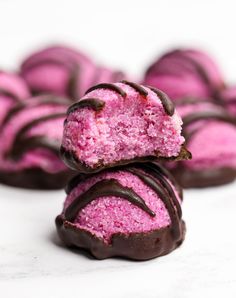 pink and chocolate donuts stacked on top of each other with one bite taken out