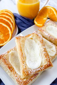 two pieces of bread on a plate with oranges next to it and a glass of orange juice