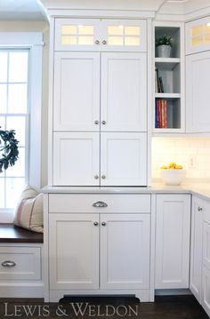 a kitchen with white cabinets and drawers