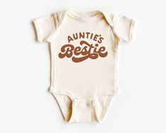 Auntie's bestie one piece romper, nephew niece gift bodysuit, pregnancy announcement one piece, baby reveal top, new infant short sleeve romper Packaging:  The item will be folded and individually package into resealable clear poly bags. It will then be placed inside a white polymail bag to be shipped to you. Material:  100 % cotton  Regular fit, midweight 180 gsm  preshrunk to minimise shrinkage Washing Instruction: Wash the T Shirt before wearing it. Cold, gentle wash setting with like colours only Flip the shirt inside out before washing Do not tumble dry Do not use harsh detergents or bleach Do not dry clean Warm iron, inside out This shirt is made in Australia. Please check our shop for more T shirts. Please leave us a review to help our shop grow. Aunties Bestie Onesie, Family Matching Short Sleeve Cotton Bodysuit, Fitted Short Sleeve Bodysuit With Letter Print, Casual Fitted Short Sleeve Bodysuit With Letter Print, Family Matching Cotton Onesie With Short Sleeves, Family Matching Cotton Short Sleeve Onesie, Fitted Onesie With Name Print For Summer, Fitted Summer Onesie With Name Print, Summer Short Sleeve Onesie With Letter Print