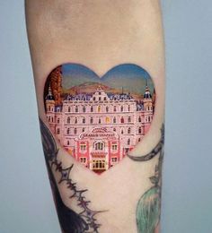 a woman's leg with a heart - shaped tattoo on it, and an image of a building in the shape of a heart