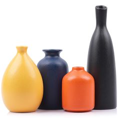 three different colored vases sitting next to each other