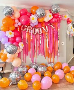 a room filled with balloons and streamers on the wall next to a doorway that says groo