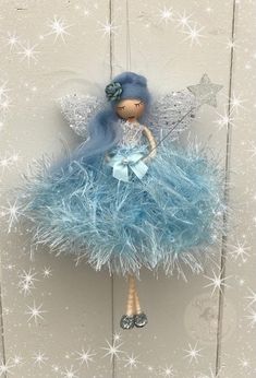 a doll with blue hair is hanging on a doorknobl decorated with snowflakes and stars