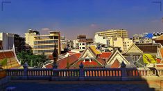 the city is full of tall buildings and colorful roof tops, with blue skies in the background