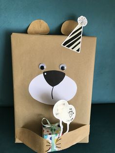 a brown paper bag with a bear cut out of it's face and some decorations