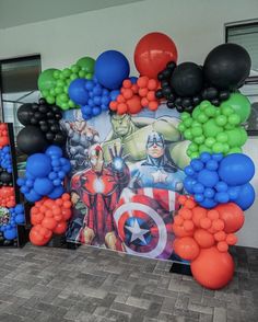 the balloon arch is decorated with captain america and avengers balloons, along with other decorations