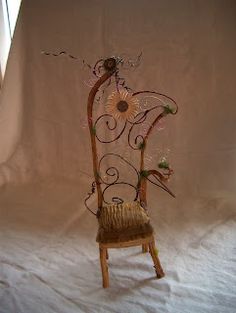 a chair made out of wood and wire with flowers on it, sitting in front of a window