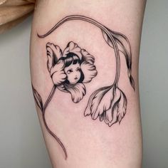 a woman's thigh with a flower and leaves tattoo design on the side of her leg