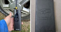 an electronic device is being held in front of a car tire and next to a manual book