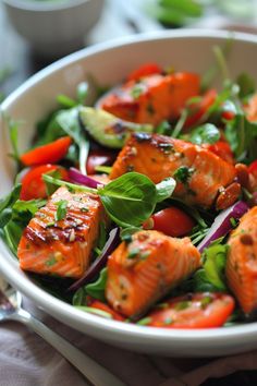 a white bowl filled with salmon and veggies