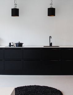 a kitchen with black cabinets and white countertops is seen in this image from the front view