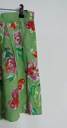 "a vintage pair of high-waisted green and pink floral pattern shorts with buttons all the way up the left side ✿ IMPORTANT INFORMATION: * excellent vintage condition * material: 100% viscose * size: small - please check exact measurements below (they're there for your benefit!) * garment care: machine washable * made in belgium ✿ MEASUREMENTS (taken while item is lying flat, some measurements will need to be doubled): * waist: 14\" (36cm) * hips: 25\" (64cm) * front rise: 14.5\" (37cm) * back ri Green Summer Bottoms With Buttons, Green Floral Print Cotton Bottoms, Green Cotton Bottoms With Floral Print, Green Spring Bottoms With Button Closure, Green Bottoms With Button Closure For Spring, Spring Green Shorts With Buttons, Spring Green Buttoned Shorts, Vintage Green Cotton Shorts, Vintage Shorts With Button Closure For Summer