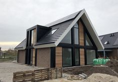 a house that is being built in the middle of some dirt and grass with windows on each side