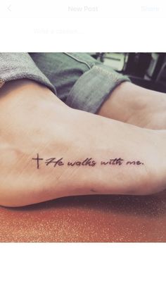 a woman's foot with a tattoo that reads, he walks with me