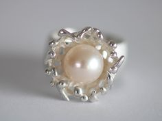 Unique ring in silver with a beautiful white pearl Size/Dimensions: Ring size 54.5 - 55 / 17.2 / 6.75 Ring rail 9.5 mm Overall width 19mm Ring size expandable up to Gr. 56 Used material: 925 silver Pearl approx. 10 mm Manufacturing method: Goldsmith handwork Unique White Pearl Ring For Formal Occasions, Silver Sterling Silver Pearl Ring For Wedding, Unique Sterling Silver Pearl Ring For Formal Occasions, Unique Sterling Silver Pearl Promise Ring, White Pearl Ring For Jewelry Making, Unique Pearl Drop Jewelry, Silver Open Pearl Ring For Jewelry Making, Unique White Pearl Ring, Unique Handmade Pearl Ring For Formal Occasions