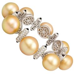 The golden South Sea pearl and diamond bracelet features eight large pearls separated by bridges set with diamonds and decorated with black onyx, lending the jewel a distinctive art déco look. The untreated pearls originate from the waters of Indonesia and measure 16.5/15.5mm in diameter. They display a beautiful nacre and their splendid natural color and high luster have not been enhanced in any way. The interspersed gold sections are set with a total of 2.80 carats of round diamonds of top qua Bracelets Pearl, Pearl Bangle Bracelet, Golden South Sea Pearls, Pearl Bracelets, Antique Bracelets, Pearl Bangle, Pearl Jewellery, White Gold Bracelet, Pearl Collection