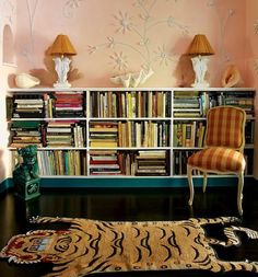 a room with bookshelves and two lamps on the wall next to each other