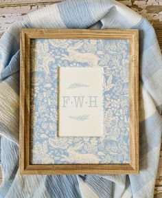 a wooden frame sitting on top of a blue and white blanket