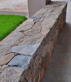 a stone bench sitting on the side of a road next to a grass covered field