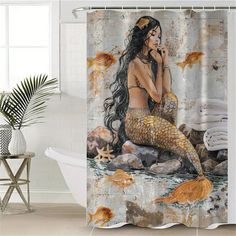 a shower curtain with a mermaid sitting on rocks and goldfish swimming in the water