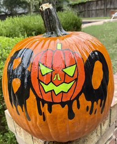 a painted pumpkin sitting on top of a brick wall