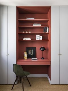 a room with a chair, bookshelf and shelves