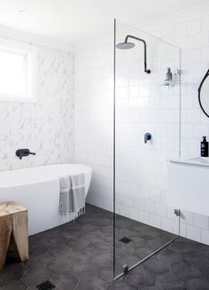 a bathroom with a white bathtub and black fixtures