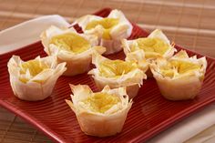 small cups filled with food sitting on top of a red plate