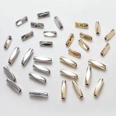 several different types of metal clips on a white surface, one is gold and the other is silver