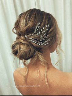 a woman wearing a hair comb with feathers on it's head and her back to the camera