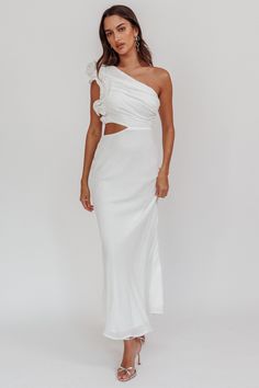 a woman wearing a white dress with one shoulder cut out and an open slit on the side