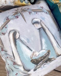 a pillow with a painting of a woman holding a baby jesus on it's back