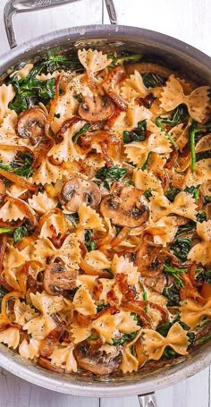 a pan filled with pasta and spinach covered in sauce