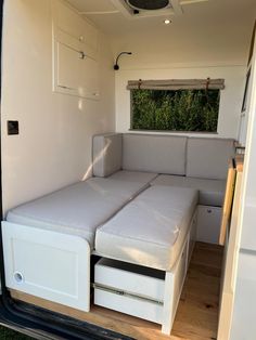 the inside of a camper with a bed and storage drawers on it's side