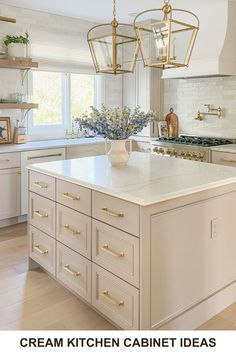 a large kitchen with white cabinets and gold hardware on the countertops, along with an island