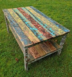 a wooden table sitting on top of a lush green field