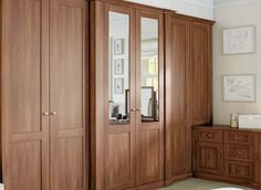 a large wooden closet with mirrored doors and drawers