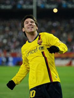 a soccer player in yellow and black uniform with his arms out to catch the ball