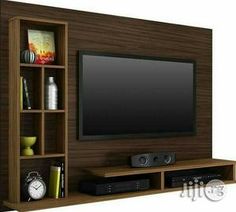 a flat screen tv mounted to the side of a wooden entertainment center with bookshelves