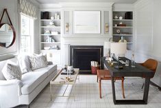 a living room filled with furniture and a fire place in the middle of a room