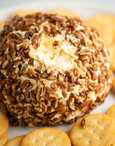 a cheese ball on a plate surrounded by crackers