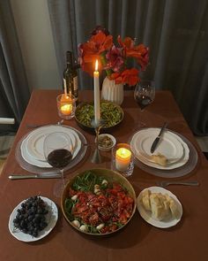 a dinner table with plates and candles on it