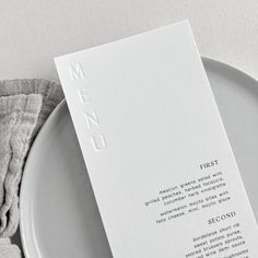 a plate with a menu on it next to a napkin